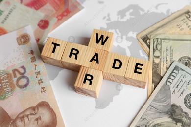 Words Trade war made of wooden cubes, dollar and yuan banknotes on world map, above view Photo of Words Trade war made of wooden cubes, dollar and yuan banknotes on world map, above view