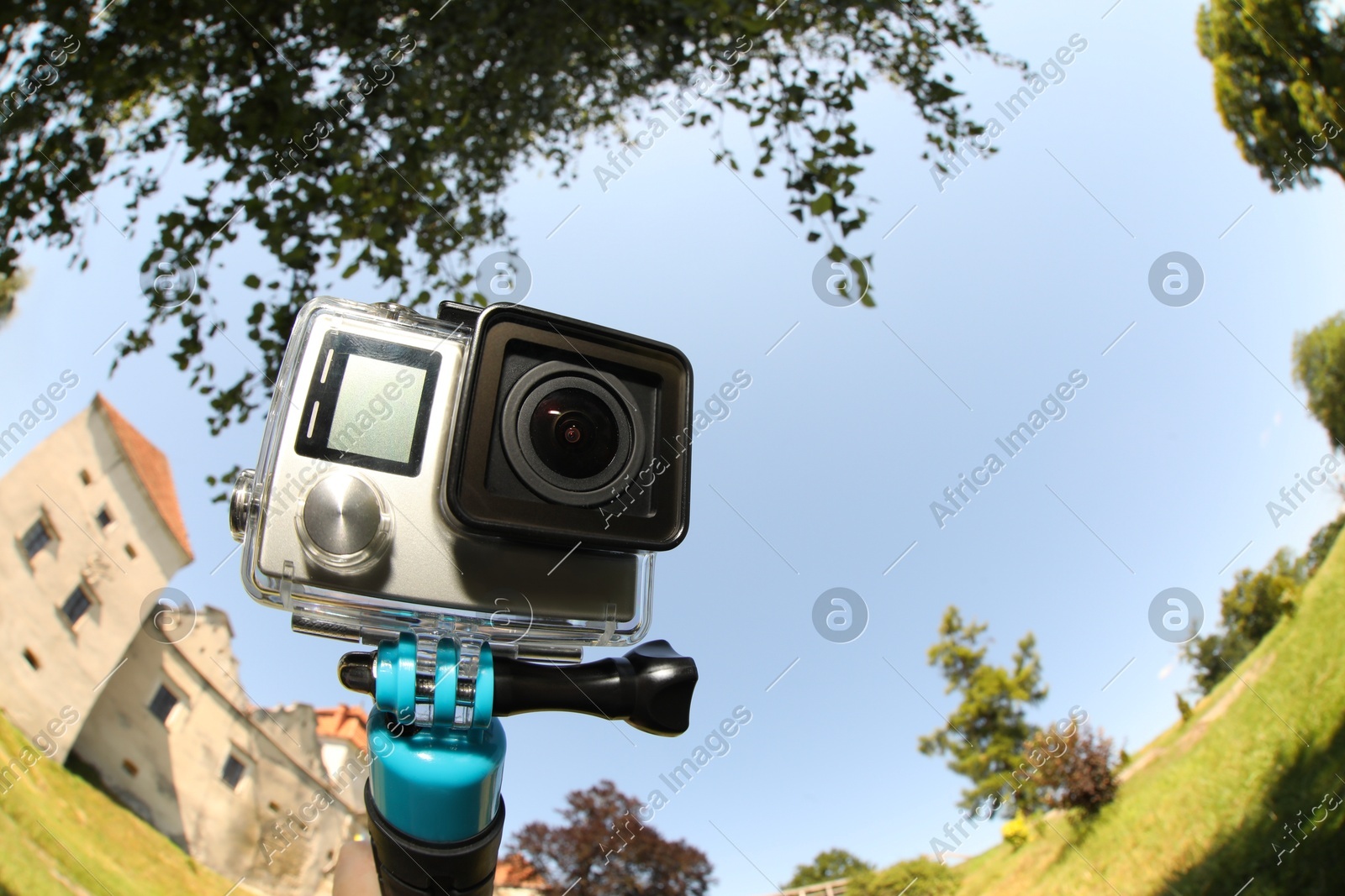 Modern action camera with monopod outdoors. Fisheye lens effect Photo of Modern action camera with monopod outdoors. Fisheye lens effect