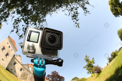 Modern action camera with monopod outdoors. Fisheye lens effect Photo of Modern action camera with monopod outdoors. Fisheye lens effect
