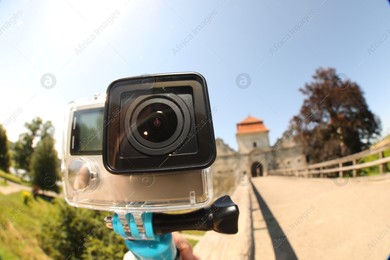 Modern action camera and monopod outdoors, closeup. Fisheye lens effect Photo of Modern action camera and monopod outdoors, closeup. Fisheye lens effect