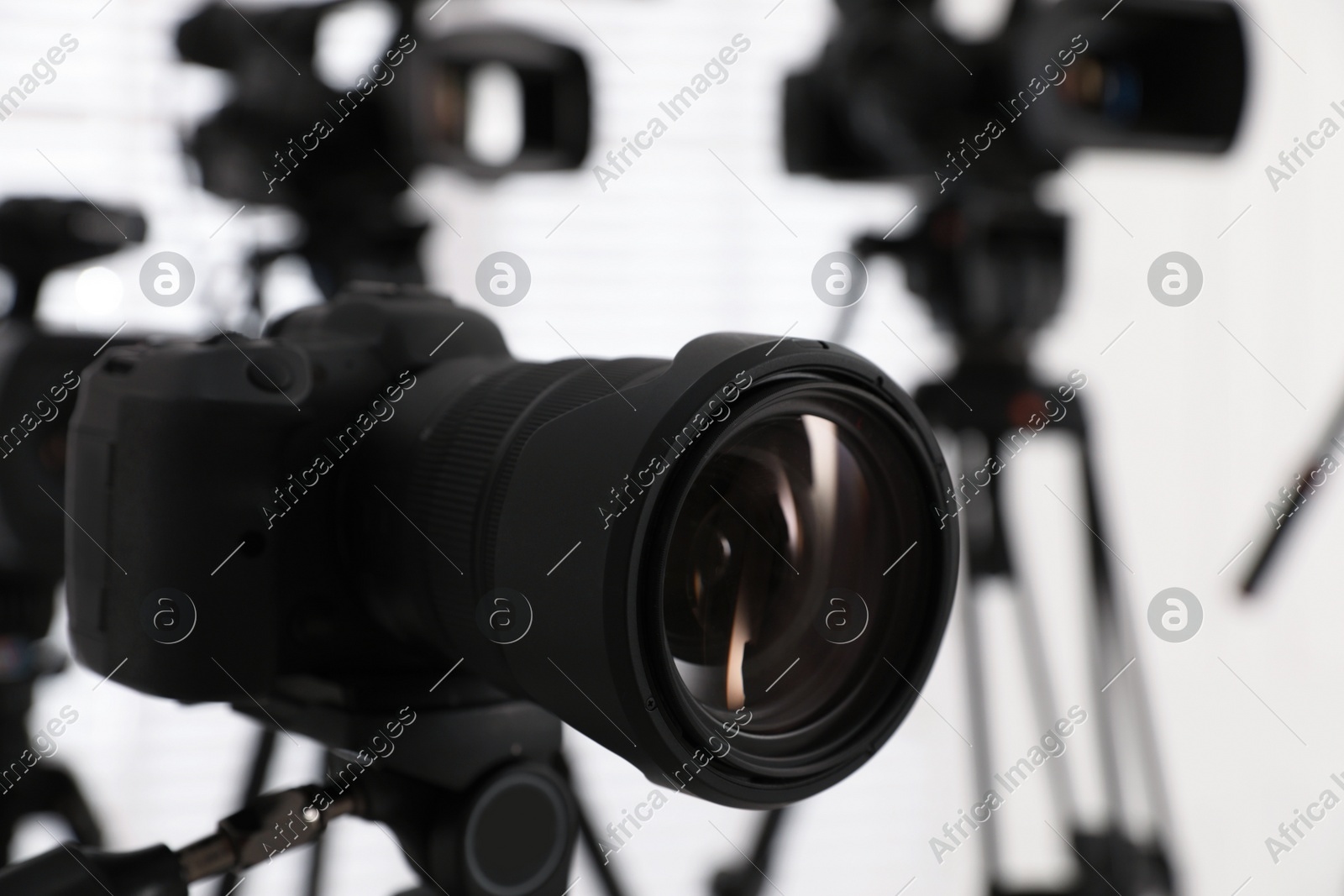 Modern video camera indoors, focus on lens. Professional media equipment for broadcasting event Photo of Modern video camera indoors, focus on lens. Professional media equipment for broadcasting event