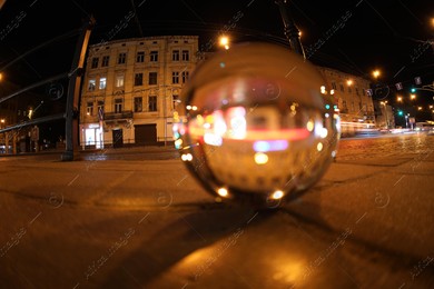 Crystal ball on asphalt road at night, selective focus. Wide-angle lens Photo of Crystal ball on asphalt road at night, selective focus. Wide-angle lens