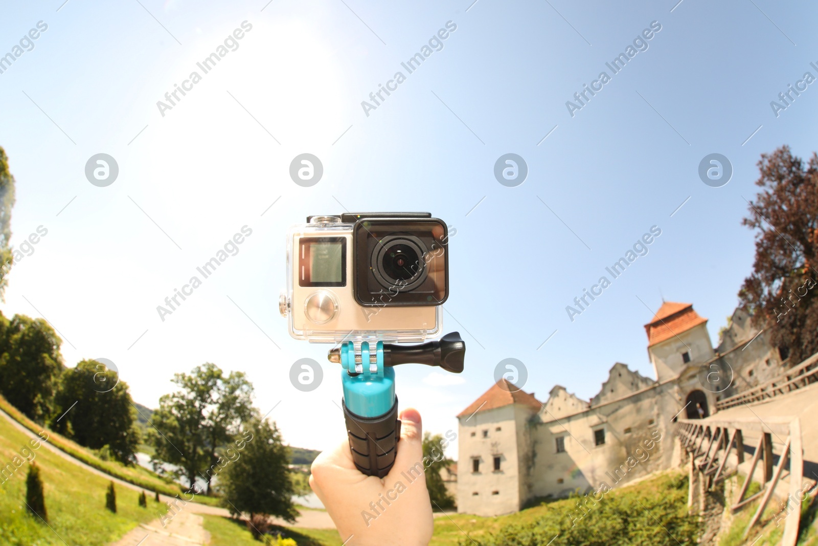 Man with modern action camera and monopod outdoors, closeup. Fisheye lens effect Photo of Man with modern action camera and monopod outdoors, closeup. Fisheye lens effect