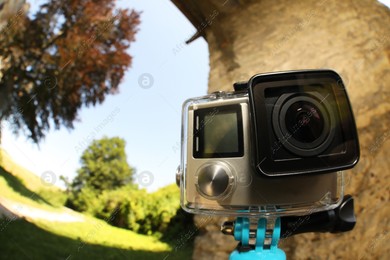 Modern action camera with monopod outdoors. Fisheye lens effect Photo of Modern action camera with monopod outdoors. Fisheye lens effect