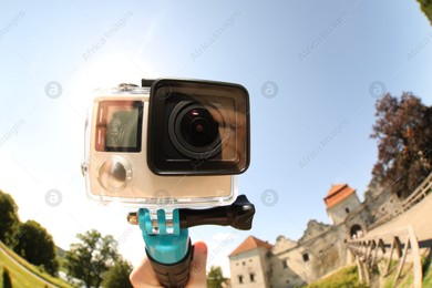 Man with modern action camera and monopod outdoors, closeup. Fisheye lens effect Photo of Man with modern action camera and monopod outdoors, closeup. Fisheye lens effect