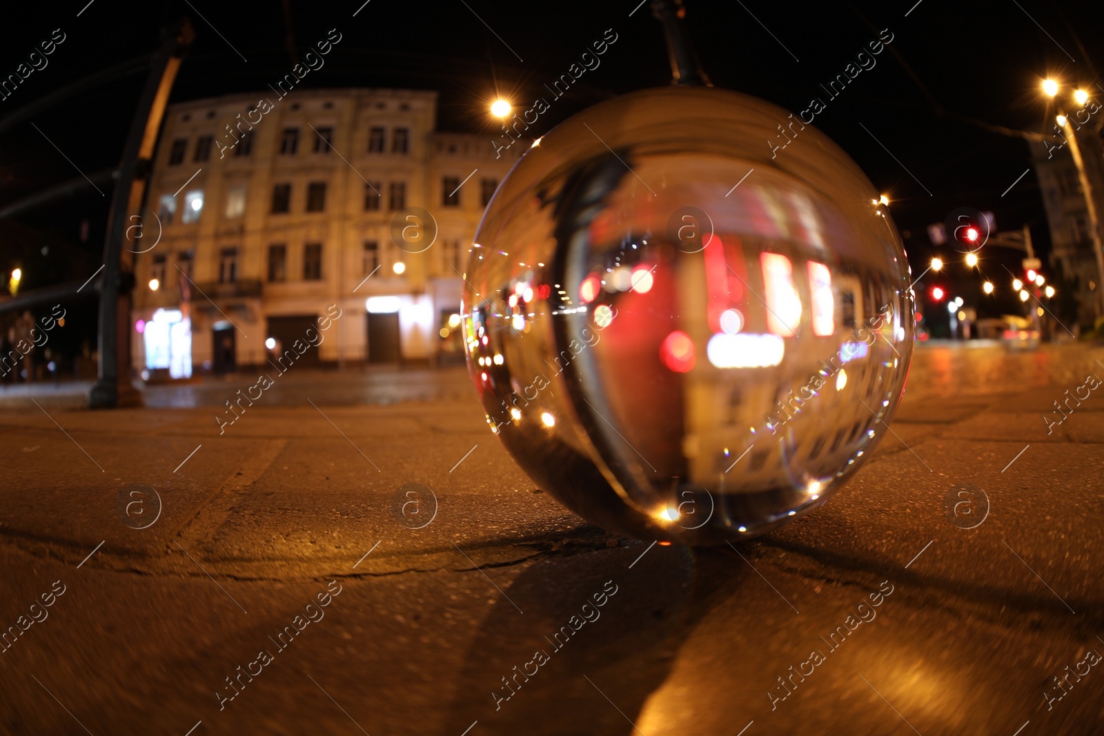 Crystal ball on asphalt road at night, selective focus. Wide-angle lens Photo of Crystal ball on asphalt road at night, selective focus. Wide-angle lens