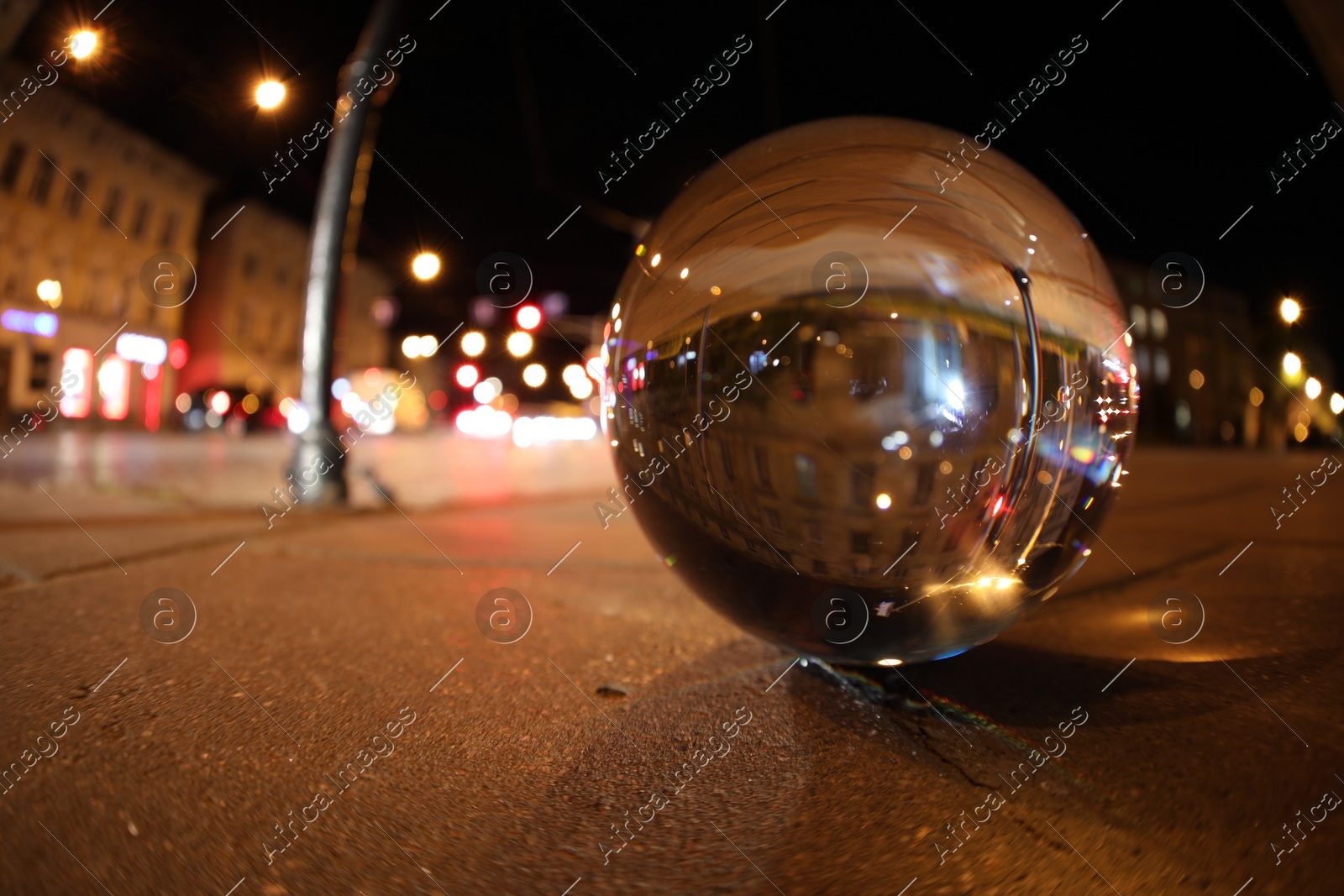 Crystal ball on asphalt road at night, space for text. Wide-angle lens Photo of Crystal ball on asphalt road at night, space for text. Wide-angle lens