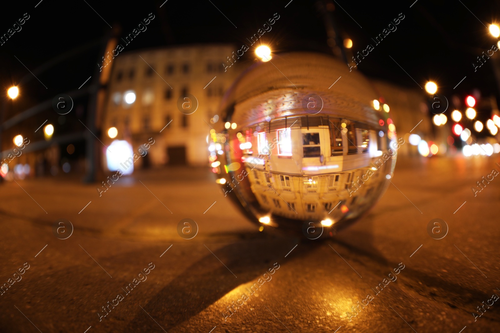 Beautiful city street, overturned reflection. Crystal ball on asphalt road at night. Wide-angle lens Photo of Beautiful city street, overturned reflection. Crystal ball on asphalt road at night. Wide-angle lens