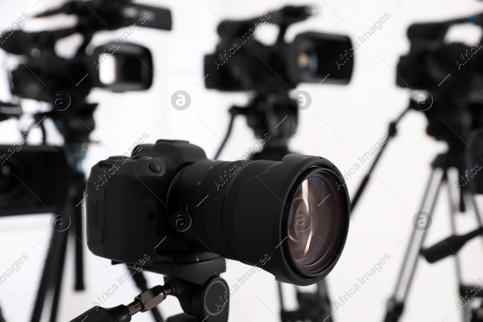 Modern video camera indoors, focus on lens. Professional media equipment for broadcasting event Photo of Modern video camera indoors, focus on lens. Professional media equipment for broadcasting event