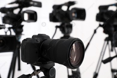 Modern video camera indoors, focus on lens. Professional media equipment for broadcasting event Photo of Modern video camera indoors, focus on lens. Professional media equipment for broadcasting event
