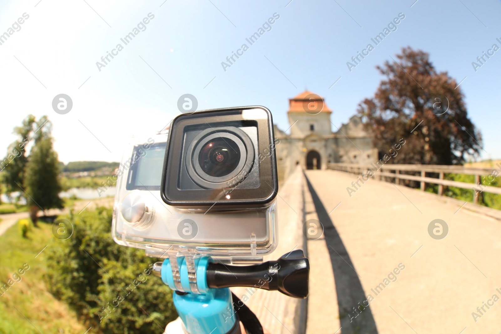 Modern action camera with monopod outdoors, closeup. Fisheye lens effect Photo of Modern action camera with monopod outdoors, closeup. Fisheye lens effect