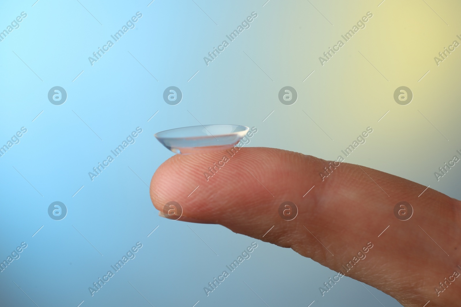 Woman holding contact lens on color background, closeup Photo of Woman holding contact lens on color background, closeup