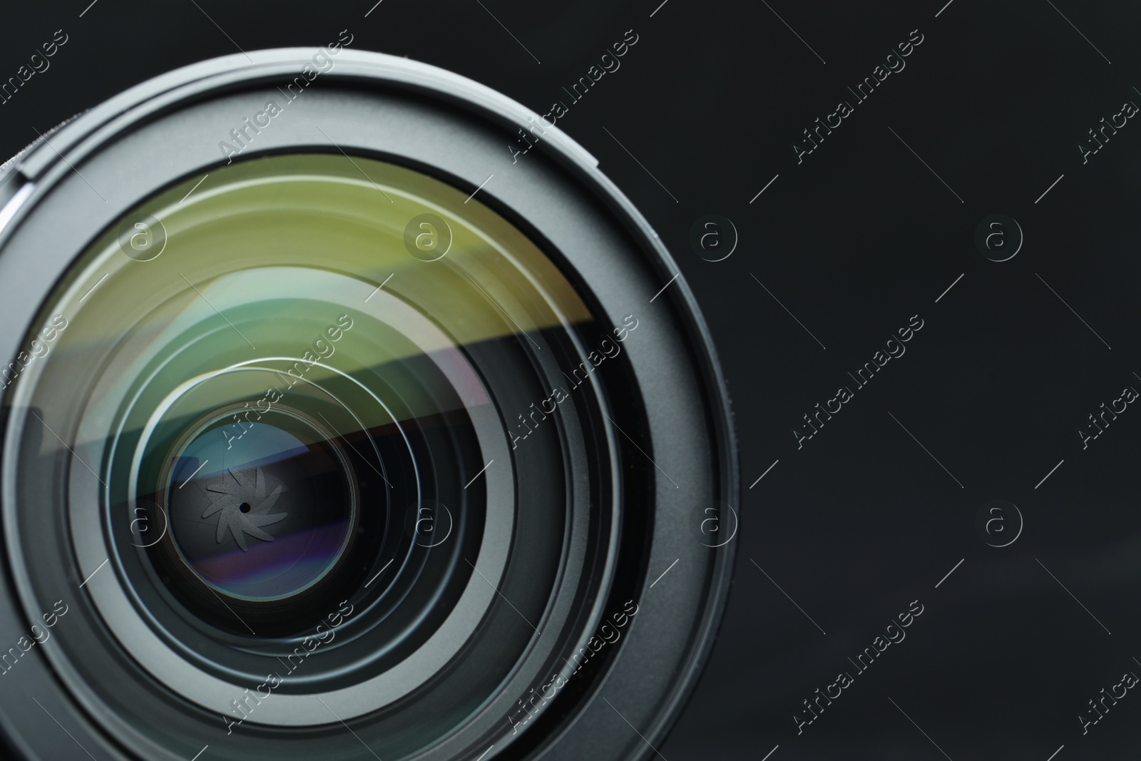 Modern camera lens on black table, closeup. Space for text Photo of Modern camera lens on black table, closeup. Space for text