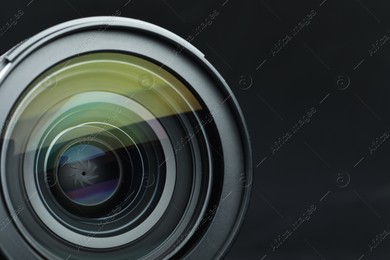 Modern camera lens on black table, closeup. Space for text Photo of Modern camera lens on black table, closeup. Space for text