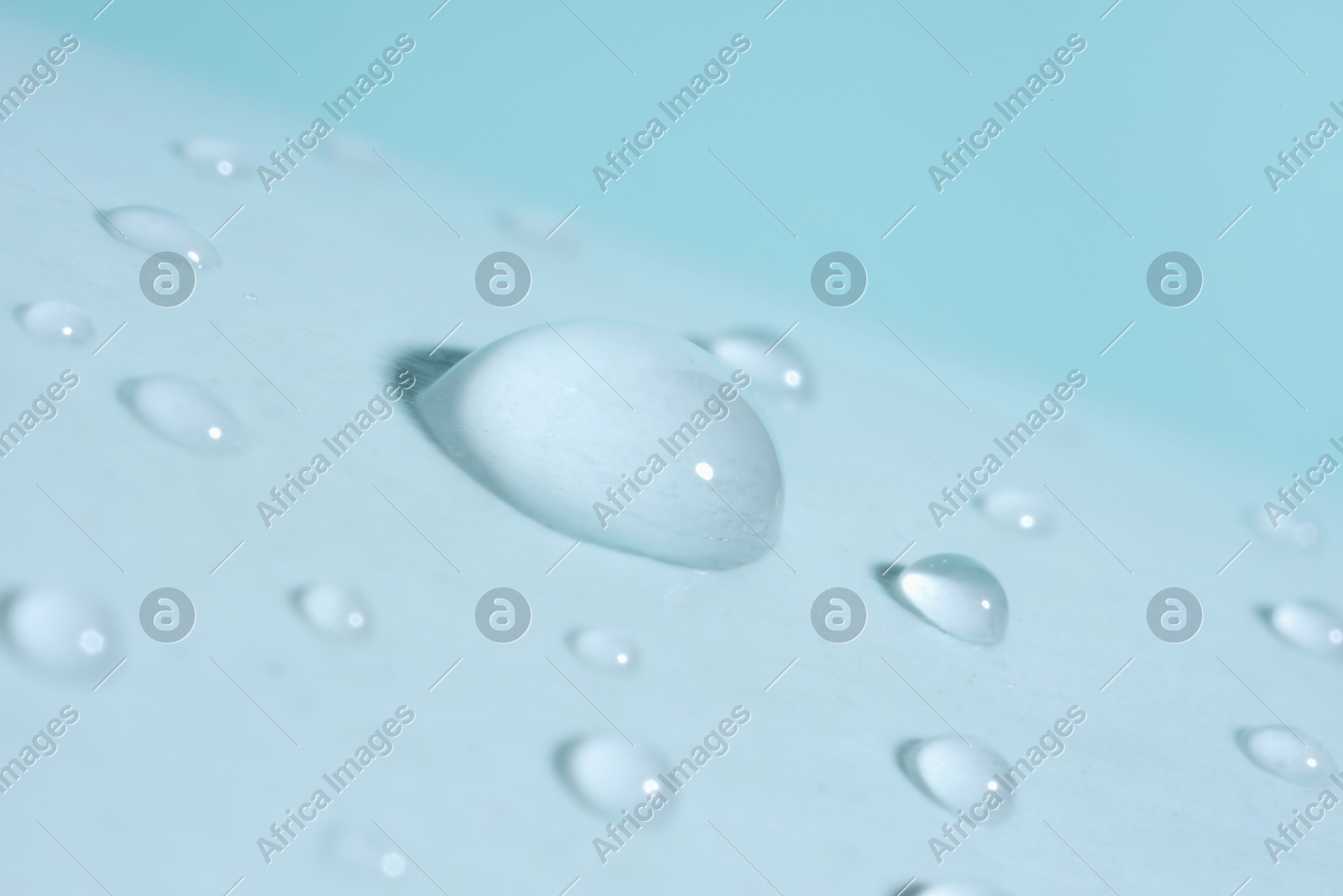 Macro photo of water drops on light blue background Photo of Macro photo of water drops on light blue background