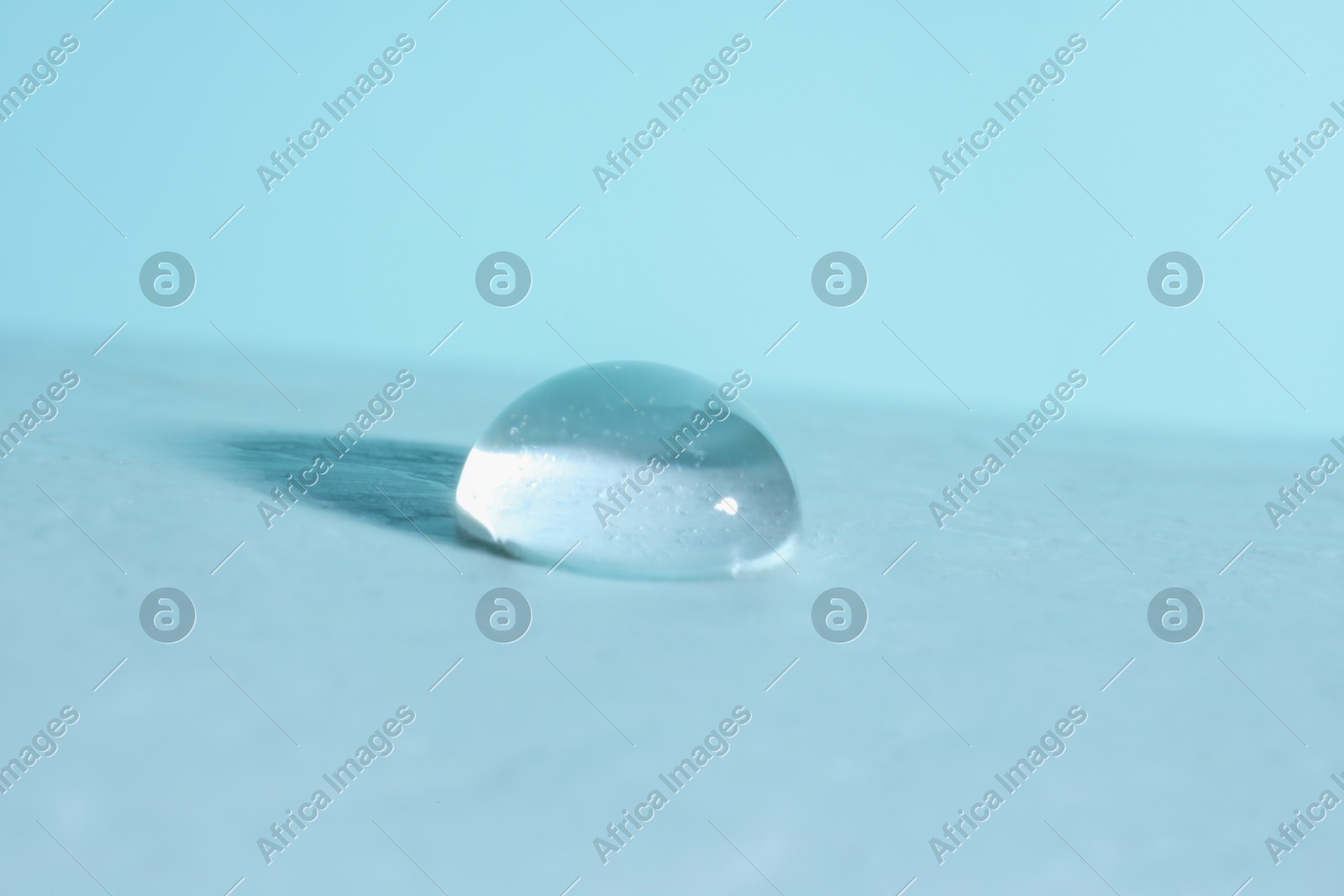 Macro photo of water drop on light blue background Photo of Macro photo of water drop on light blue background