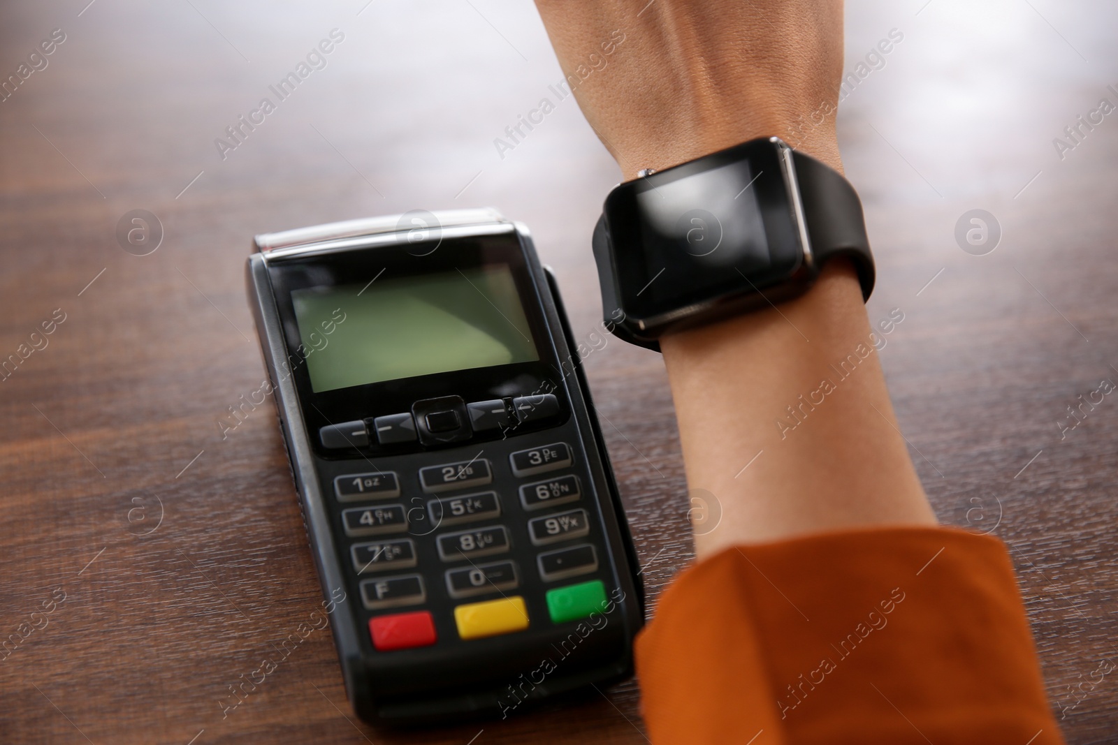 Woman making payment with smart watch at table, closeup Photo of Woman making payment with smart watch at table, closeup
