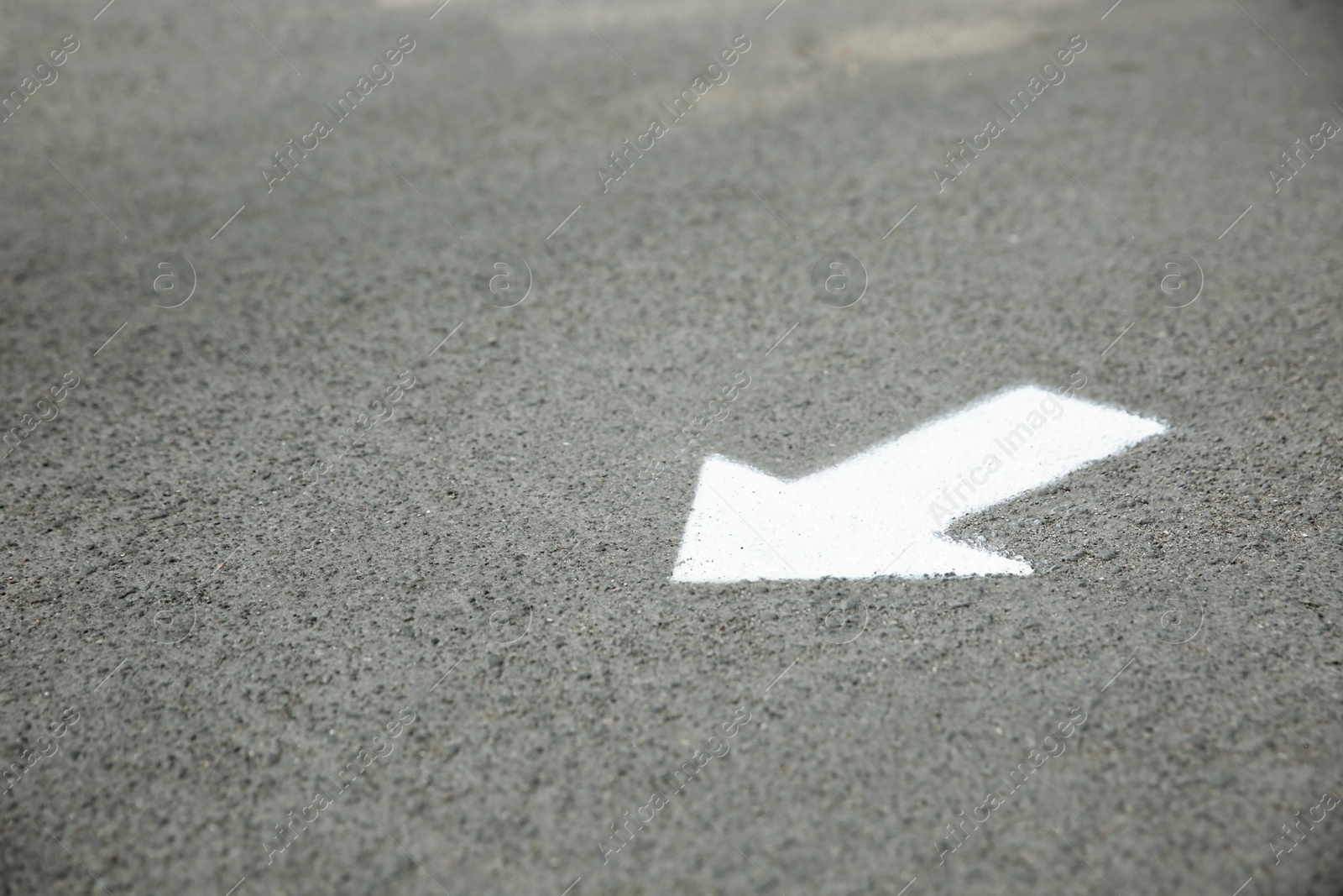White arrow painted on asphalt. Space for text Photo of White arrow painted on asphalt. Space for text