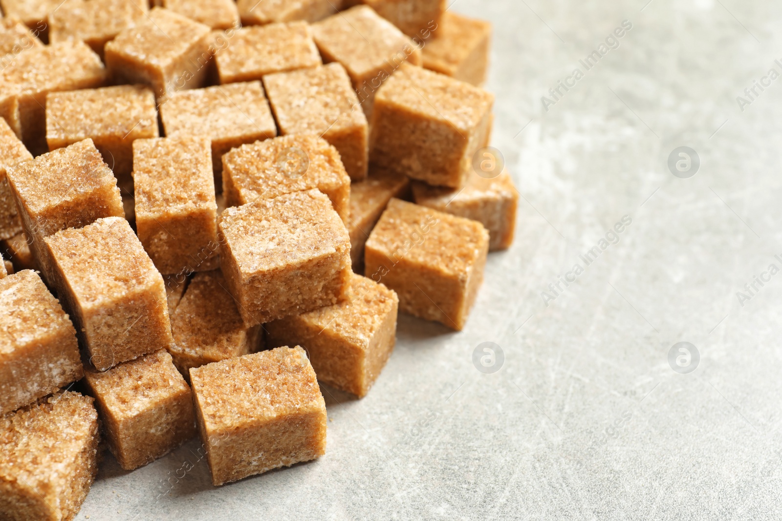 Cubes of brown sugar on gray table Photo of Cubes of brown sugar on gray table