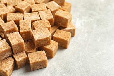Cubes of brown sugar on gray table Photo of Cubes of brown sugar on gray table