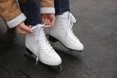 Woman lacing figure skate outdoors, closeup view Photo of Woman lacing figure skate outdoors, closeup view