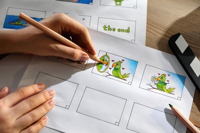 Woman drawing cartoon sketches at workplace, closeup. Pre-production process Photo of Woman drawing cartoon sketches at workplace, closeup. Pre-production process