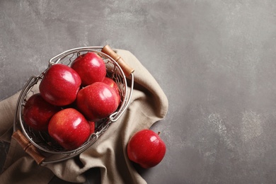 Basket with fresh ripe red apples on grey background Photo of Basket with fresh ripe red apples on grey background