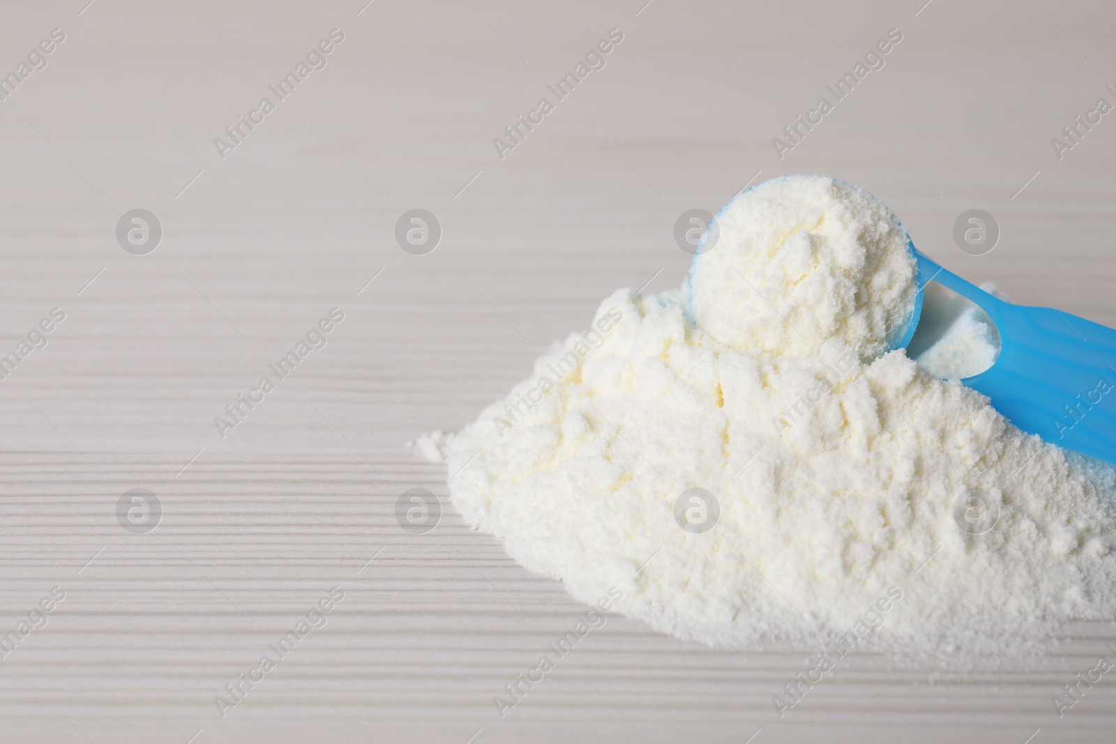 Powdered infant formula and scoop on white wooden table, closeup with space for text. Baby milk Photo of Powdered infant formula and scoop on white wooden table, closeup with space for text. Baby milk