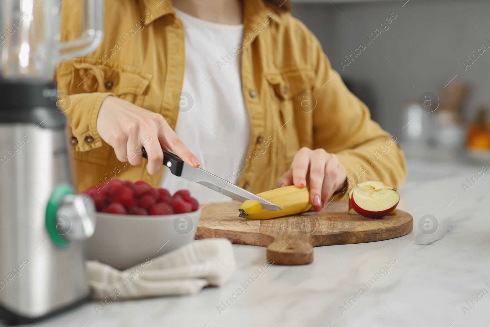 Woman preparing ingredients for tasty smoothie at white marble table in kitchen, closeup Photo of Woman preparing ingredients for tasty smoothie at white marble table in kitchen, closeup