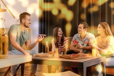 Image of Group of friends having fun party with delicious pizza in cafe, bokeh effect