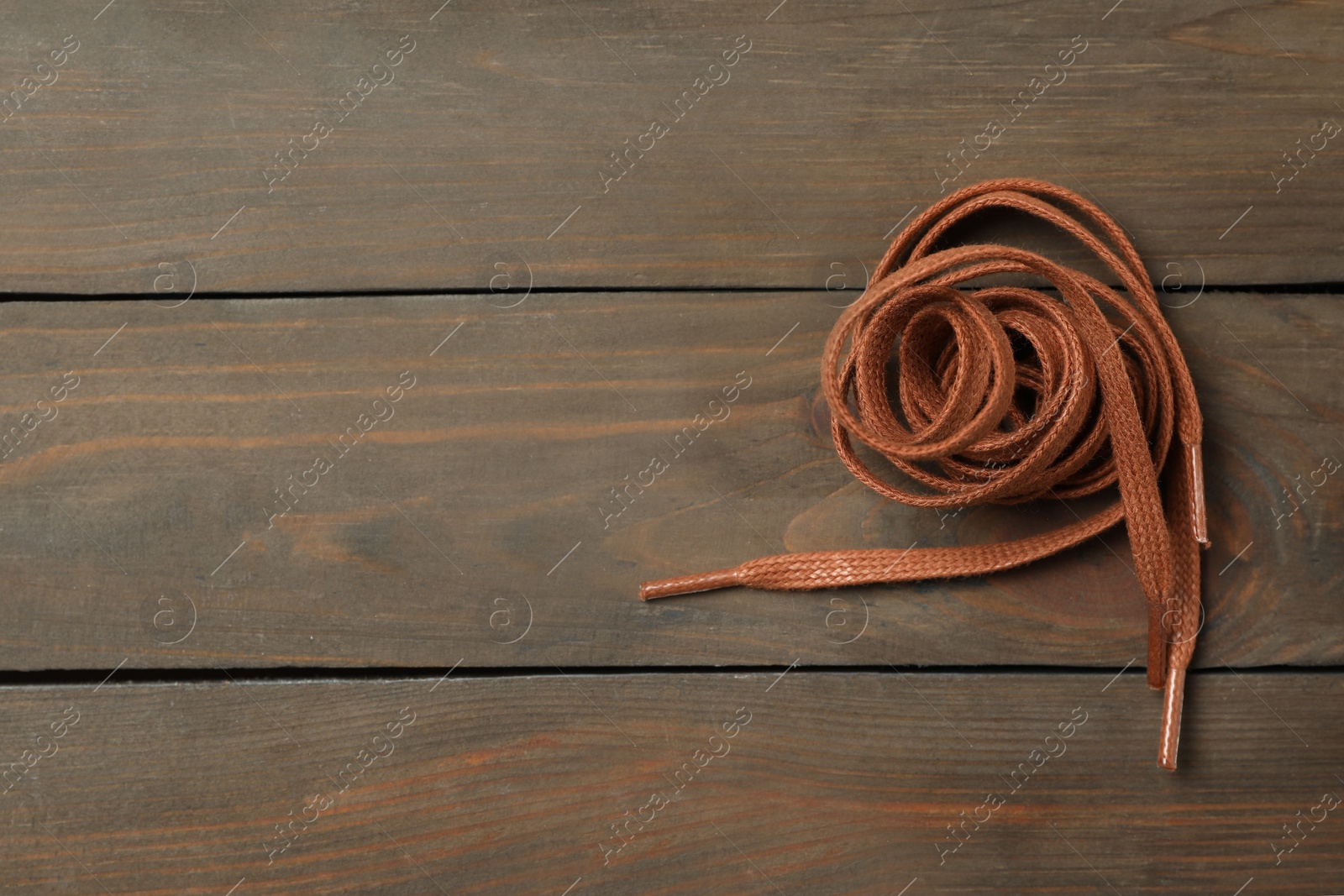 Brown shoelaces on wooden background, top view. Space for text Photo of Brown shoelaces on wooden background, top view. Space for text