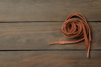 Brown shoelaces on wooden background, top view. Space for text Photo of Brown shoelaces on wooden background, top view. Space for text