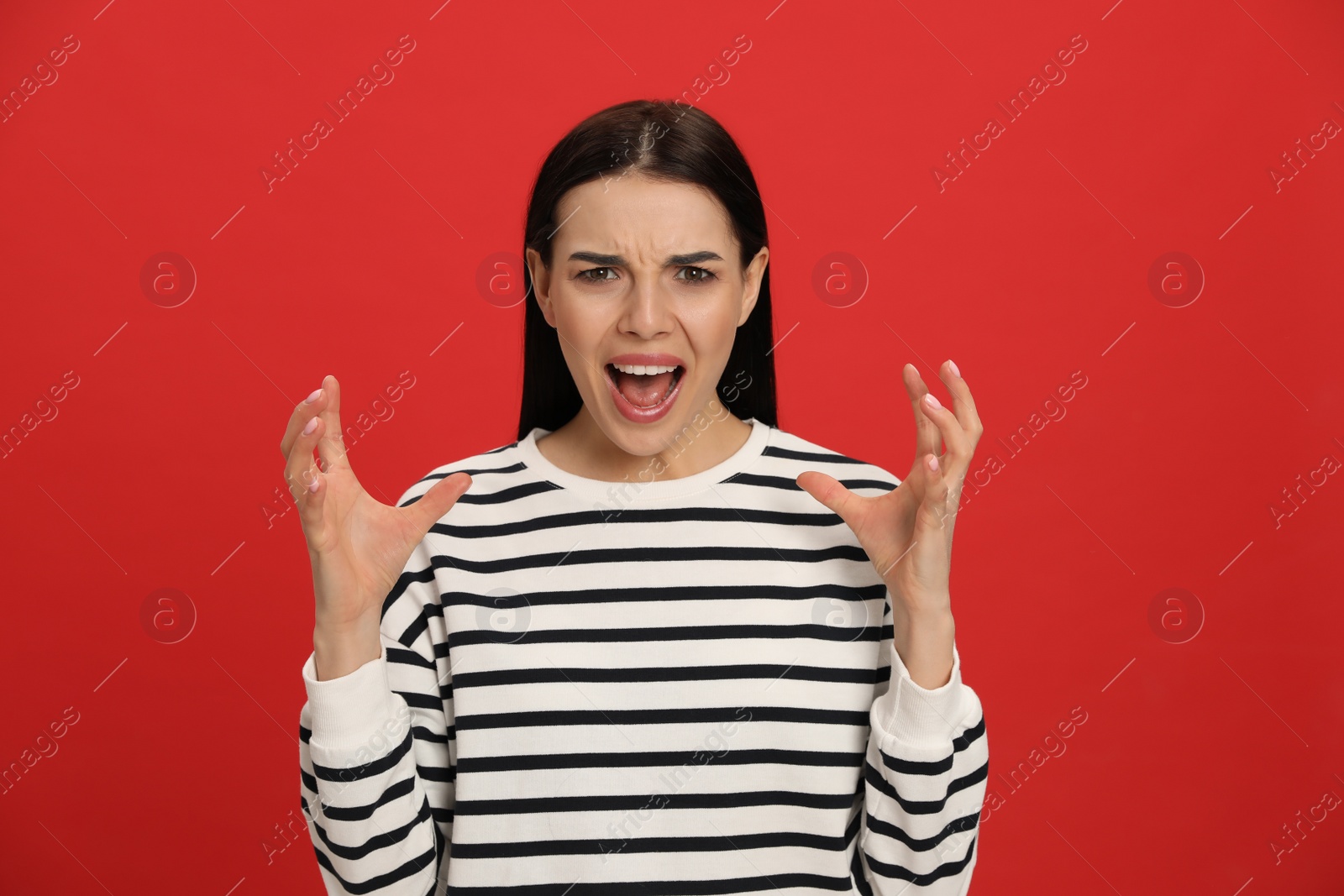 Angry young woman on red background. Hate concept Photo of Angry young woman on red background. Hate concept