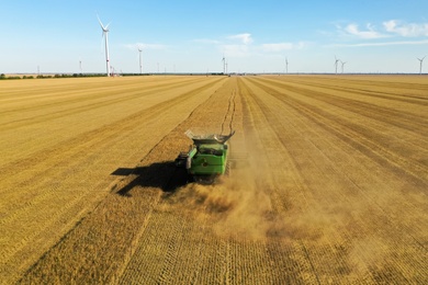 Modern combine harvester working in field on sunny day. Agriculture industry Photo of Modern combine harvester working in field on sunny day. Agriculture industry