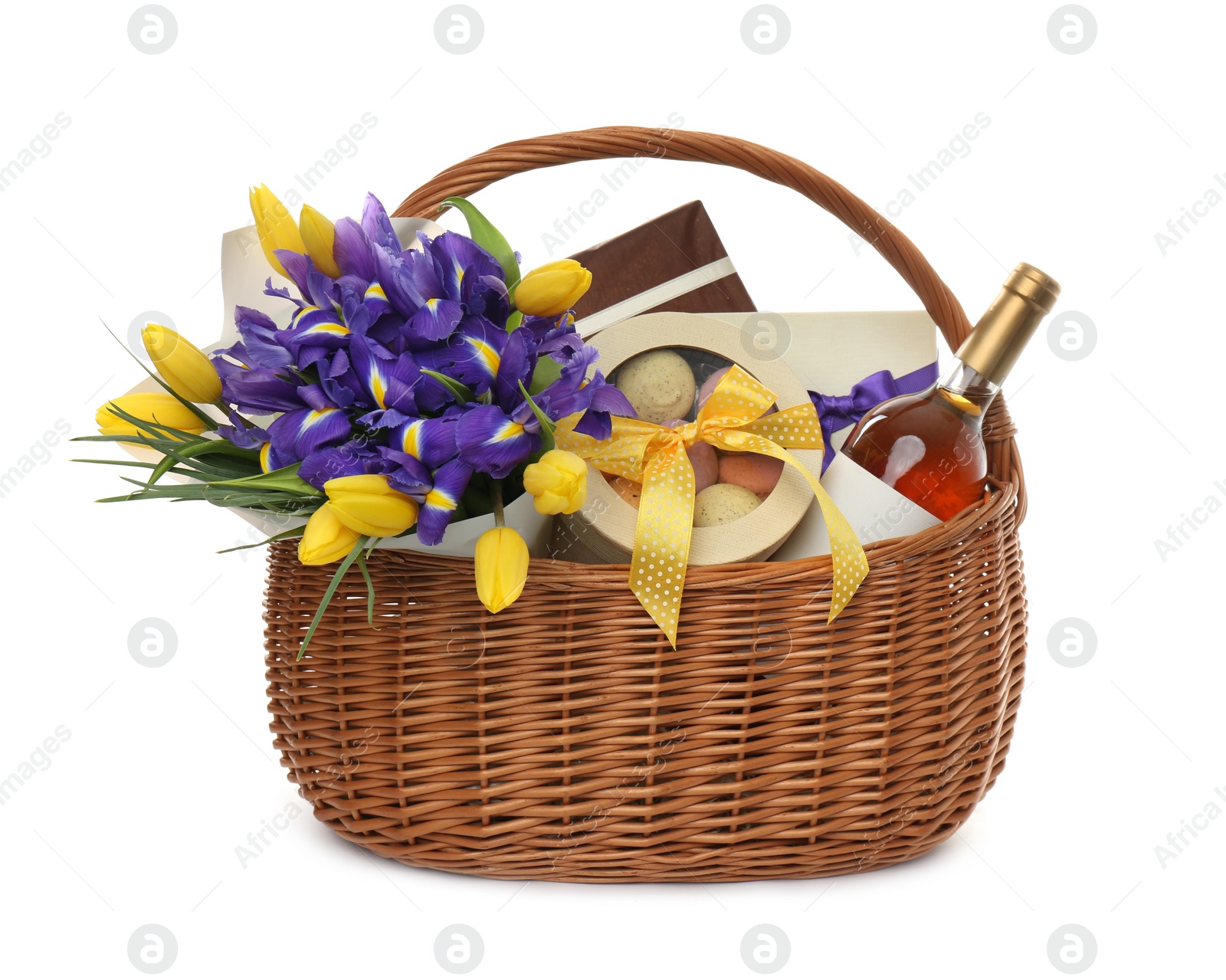 Wicker basket with gift, bouquet and wine on white background Photo of Wicker basket with gift, bouquet and wine on white background