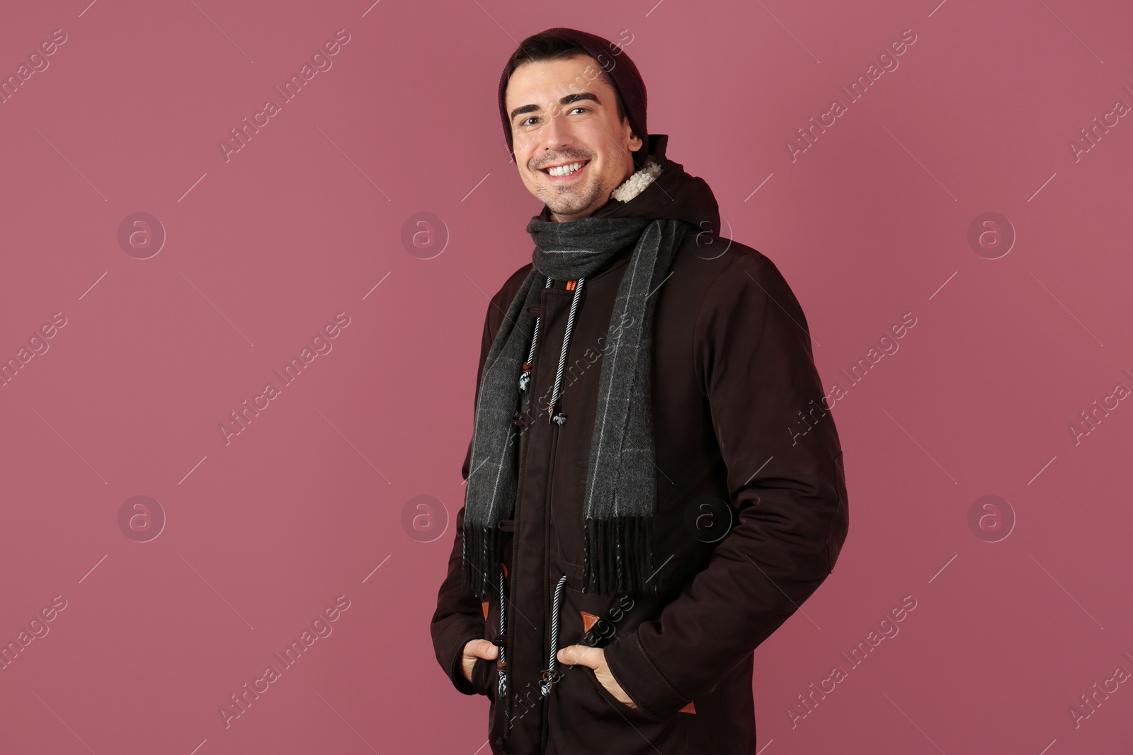 Portrait of happy young man in warm clothing on color background. Ready for winter vacation Photo of Portrait of happy young man in warm clothing on color background. Ready for winter vacation