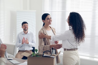 Boss shaking hand with new employee and coworkers applauding in office Photo of Boss shaking hand with new employee and coworkers applauding in office