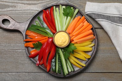 Different vegetables cut in sticks and dip sauce on wooden table, flat lay Photo of Different vegetables cut in sticks and dip sauce on wooden table, flat lay