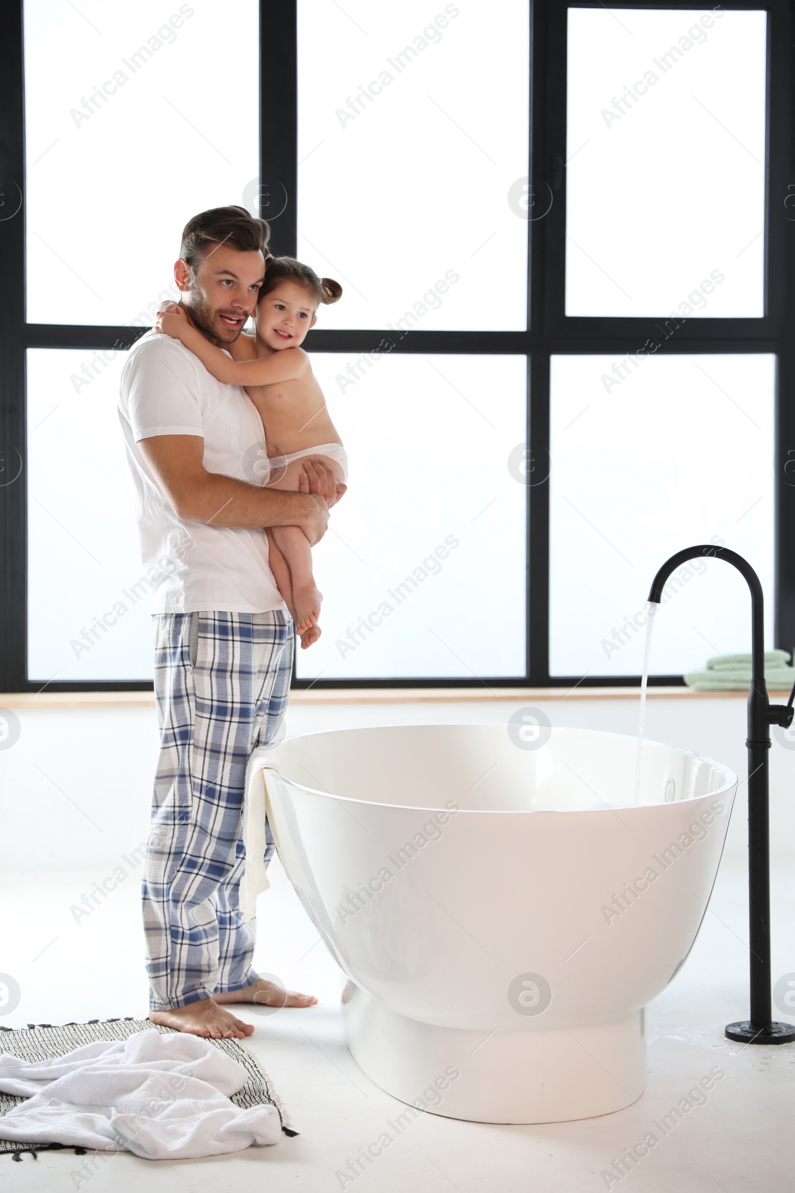 Young father with cute little daughter in bathroom Photo of Young father with cute little daughter in bathroom