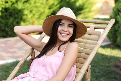 Young woman resting in deck chair outdoors Image of Young woman resting in deck chair outdoors