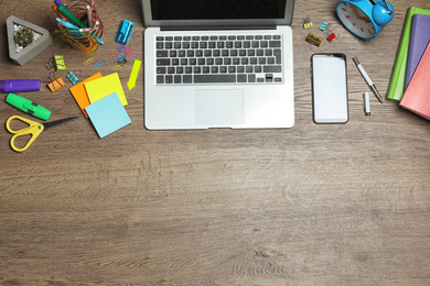 Flat lay composition with laptop, smartphone and stationery on wooden table, space for text. Designer's workplace Photo of Flat lay composition with laptop, smartphone and stationery on wooden table, space for text. Designer's workplace