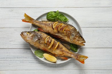 Tasty homemade roasted perches on white wooden table, top view. River fish Photo of Tasty homemade roasted perches on white wooden table, top view. River fish