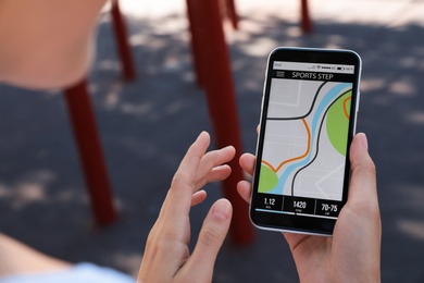 Young woman using fitness app on smartphone outdoors, closeup Photo of Young woman using fitness app on smartphone outdoors, closeup