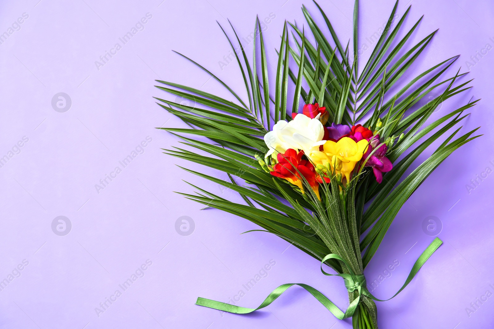 Beautiful freesia bouquet on color background Photo of Beautiful freesia bouquet on color background