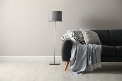 Stylish comfortable sofa in room, space for text. Interior design Photo of Stylish comfortable sofa in room, space for text. Interior design