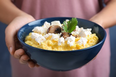 Woman holding bowl of banosh with brynza and mushrooms, closeup. Traditional Ukrainian dish Photo of Woman holding bowl of banosh with brynza and mushrooms, closeup. Traditional Ukrainian dish