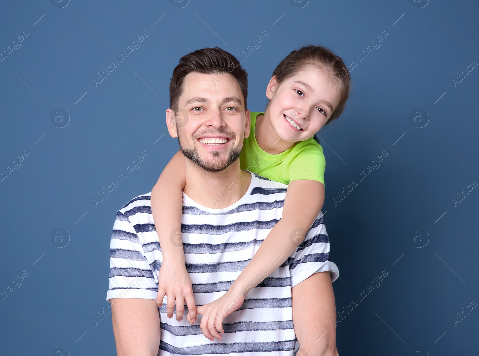 Dad and his daughter hugging on color background. Father's day celebration Photo of Dad and his daughter hugging on color background. Father's day celebration