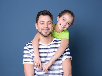 Photo of Dad and his daughter hugging on color background. Father's day celebration