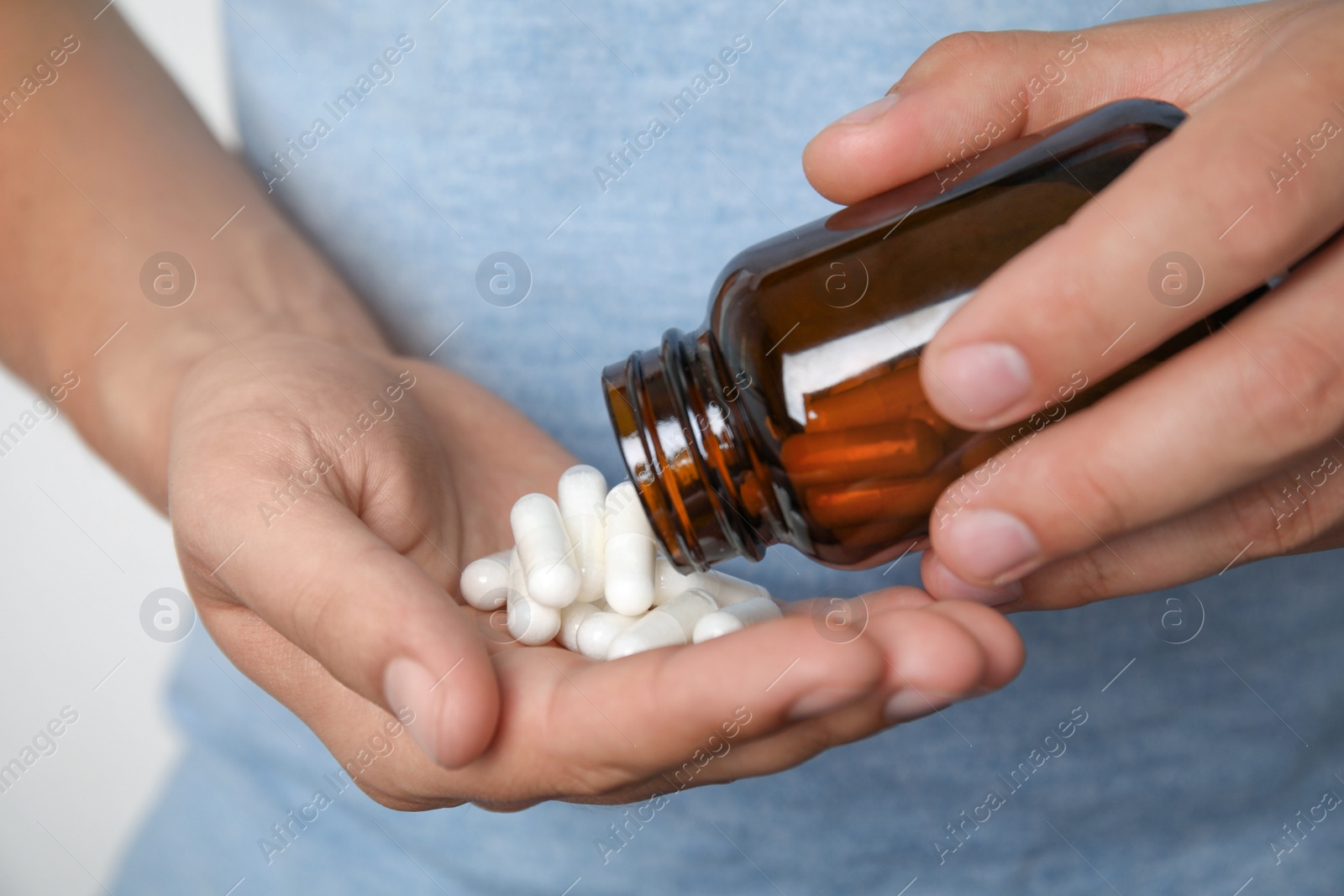 Man with amino acids pills on light background, closeup Photo of Man with amino acids pills on light background, closeup