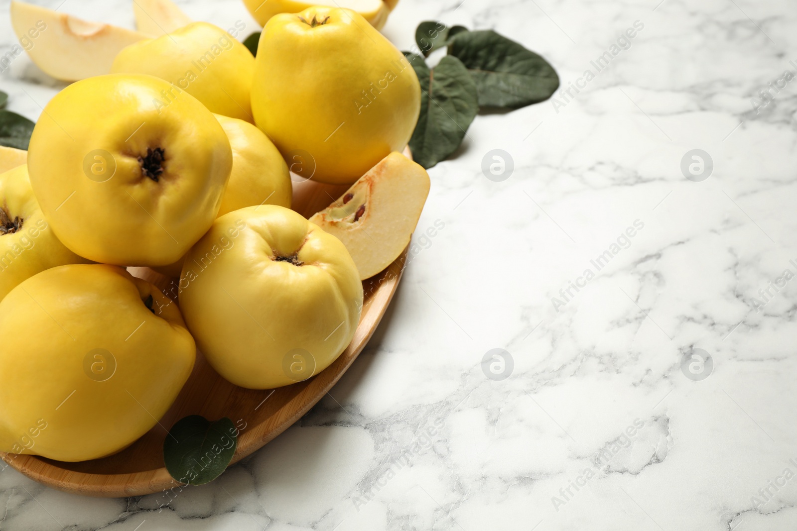 Fresh ripe organic quinces on white marble table. Space for text Photo of Fresh ripe organic quinces on white marble table. Space for text